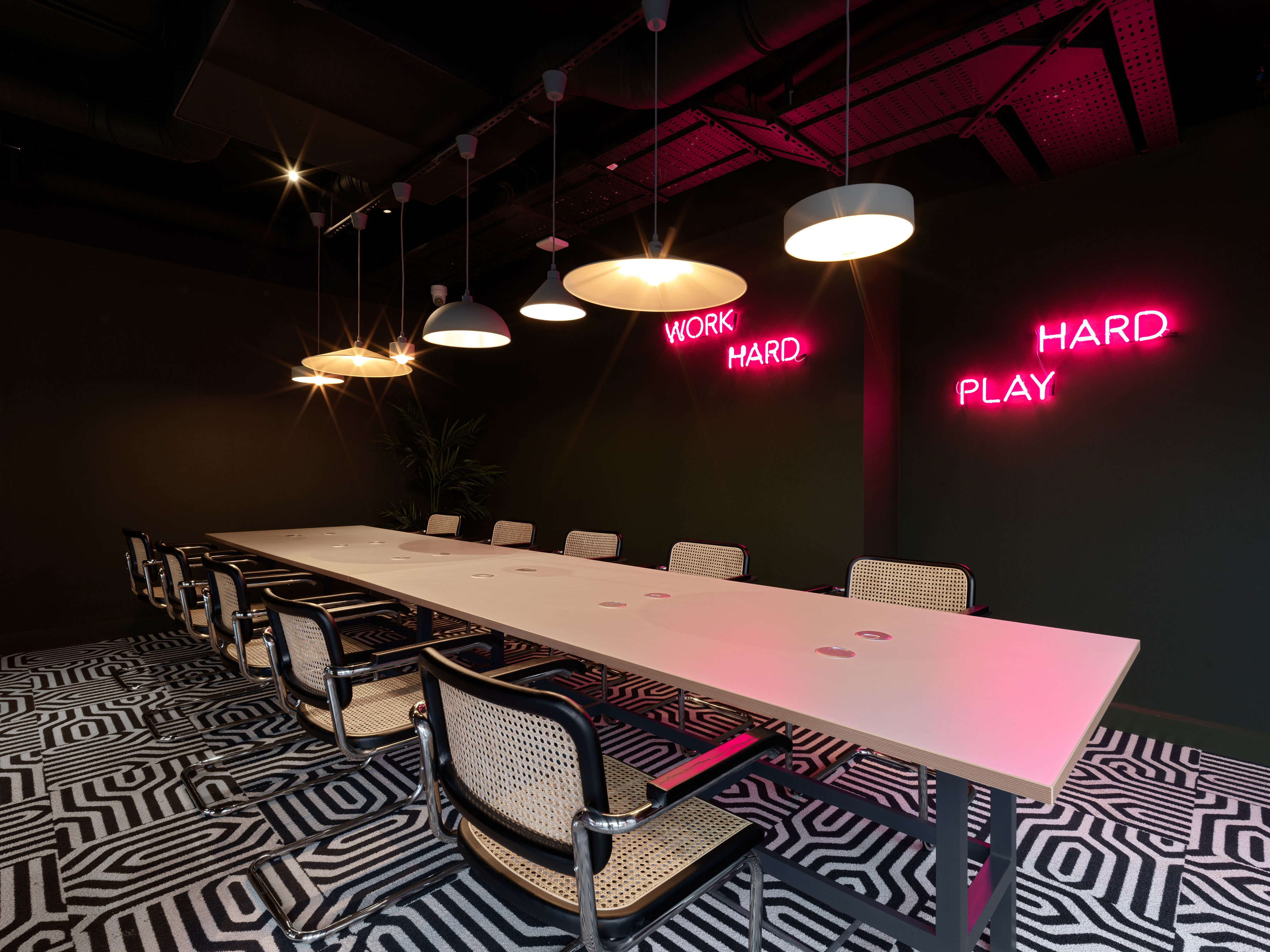 Meeting room with a long table and neon wall signage