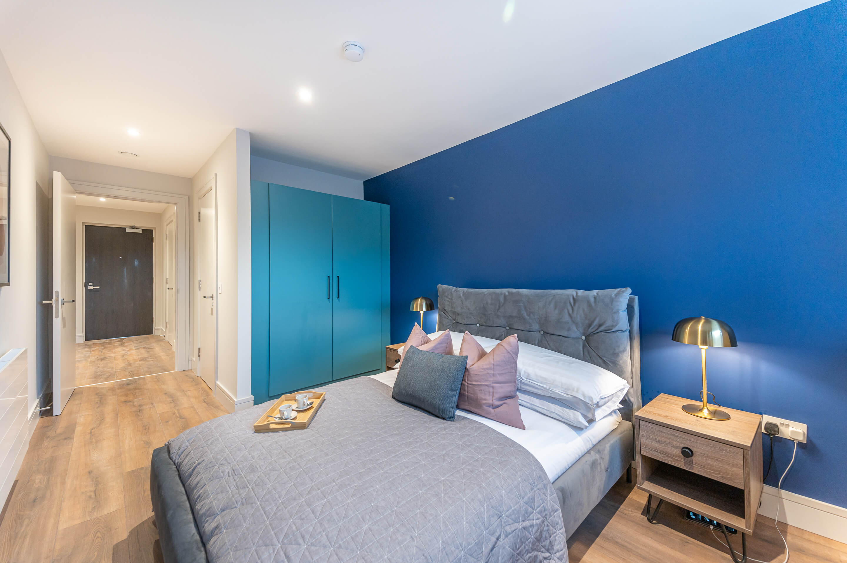 Stylish bedroom with blue accent wall and modern furnishings