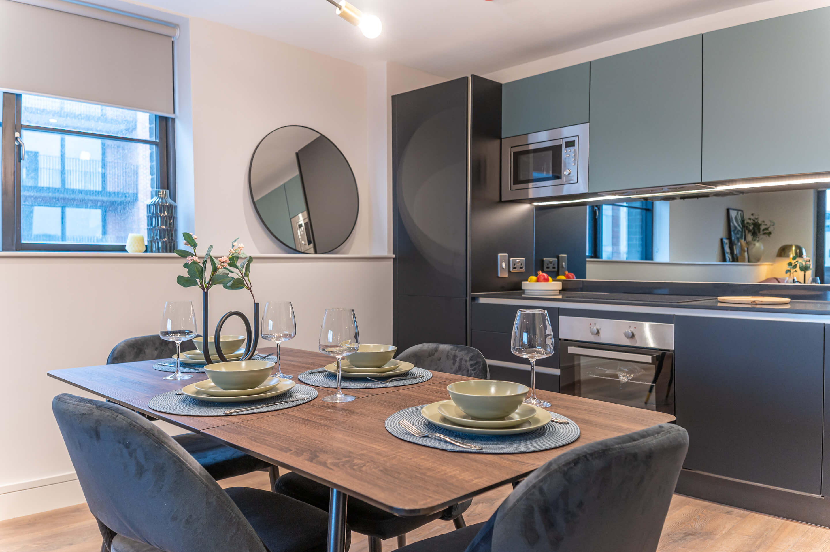 Elegant dining area with teal kitchen and table setting