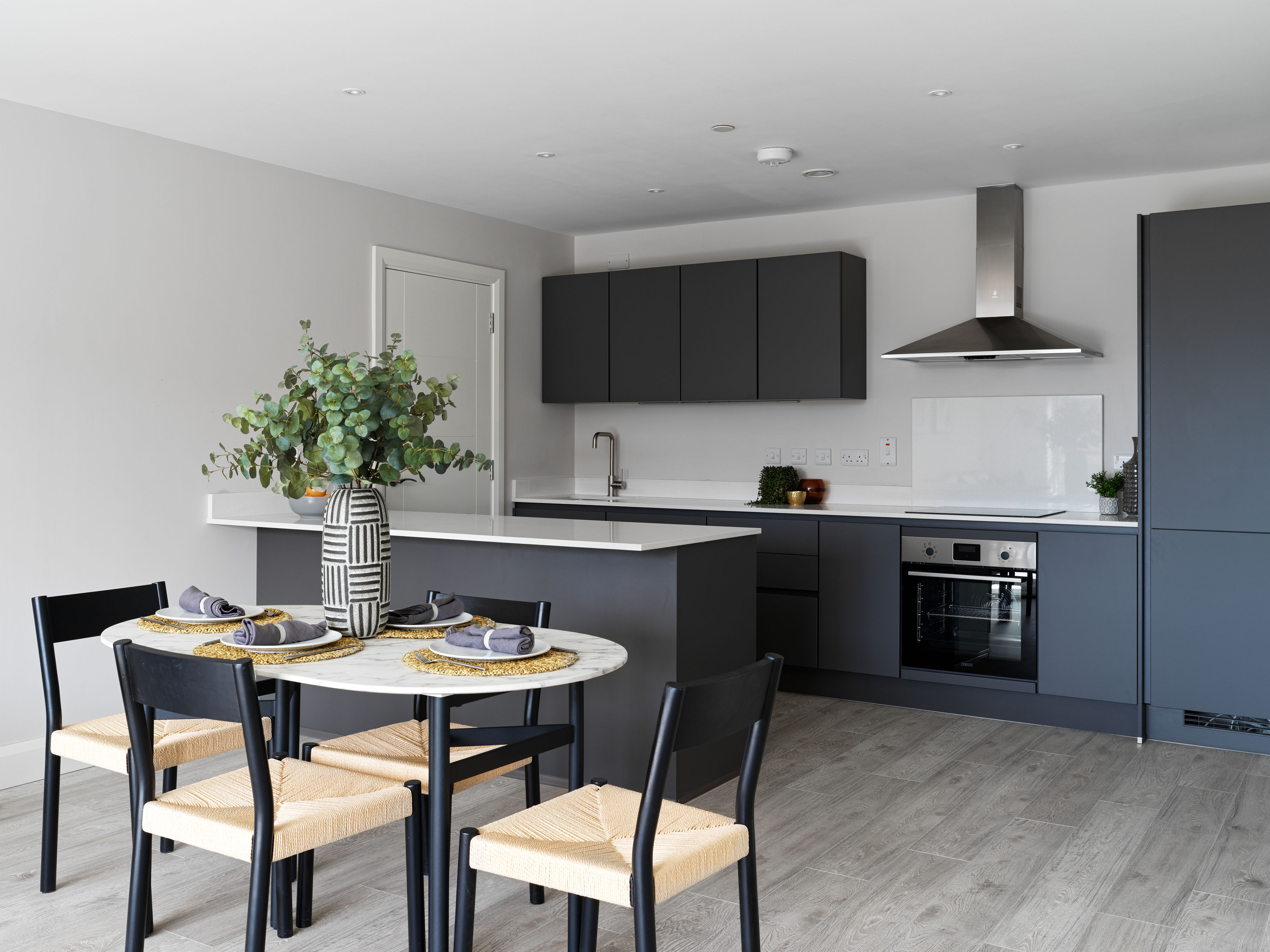 Modern kitchen with dark cabinetry and dining area