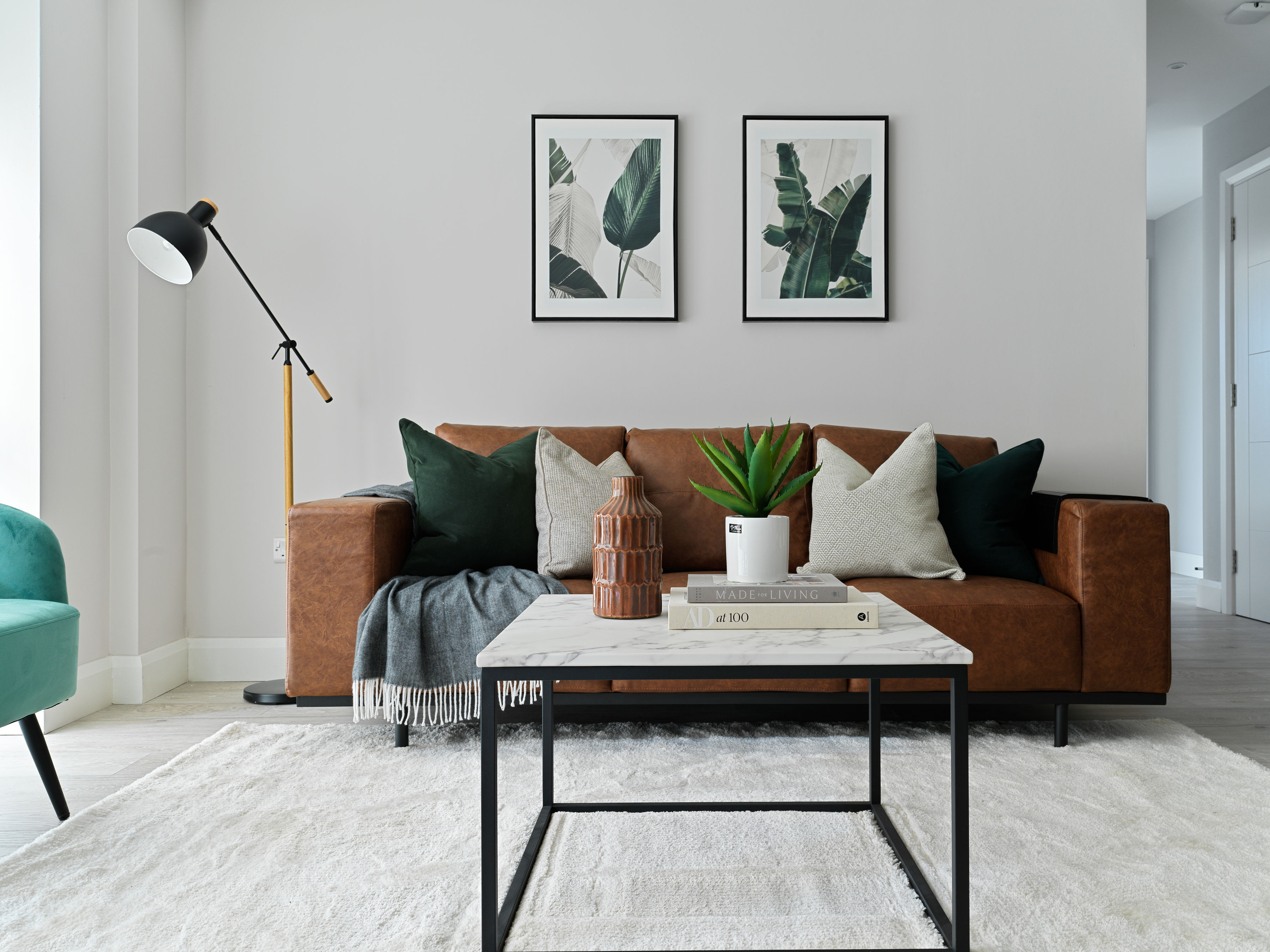 Contemporary living room with leather sofa and botanical prints