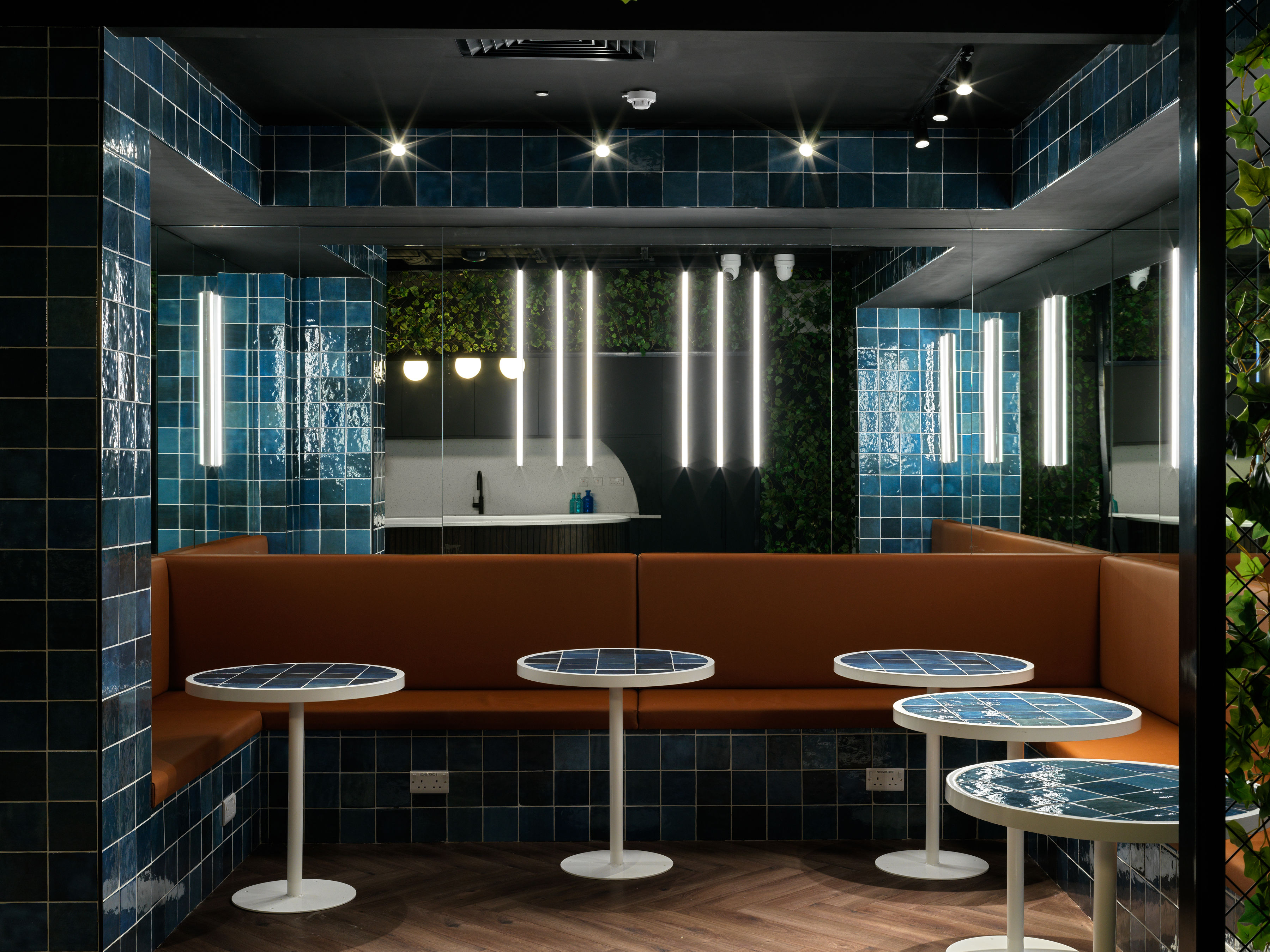 Diner-style booth with blue tiled walls and banquette seating