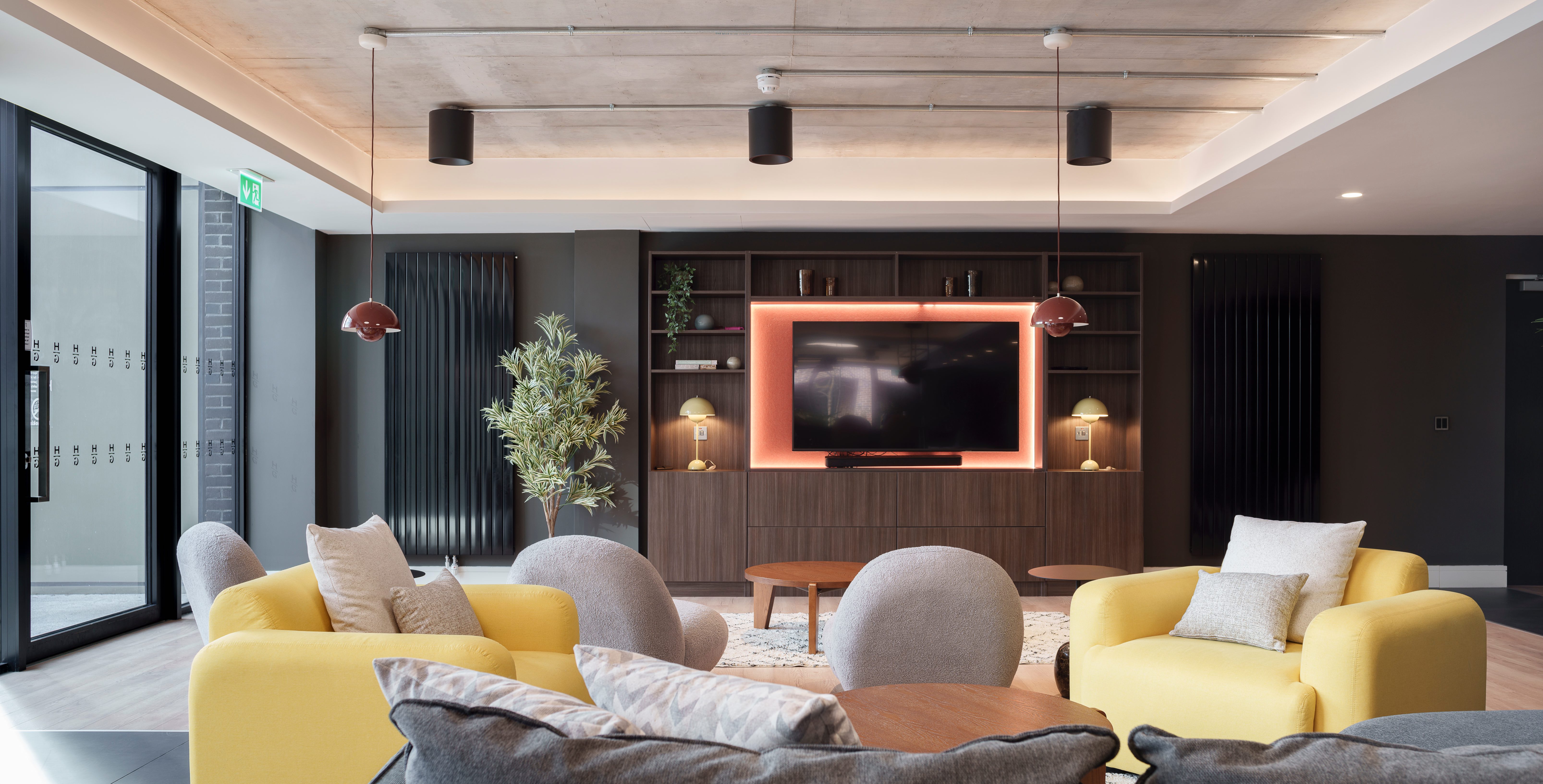 Resident lounge with yellow sofas and a large screen